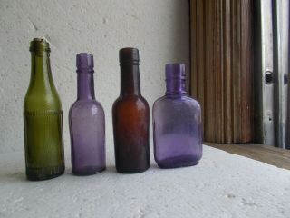 GROUP OF 4 DIFFERENT MINIATURE SAMPLE SIZE WHISKEY BOTTLES 2 AMETHYST HAND BLOWN 2