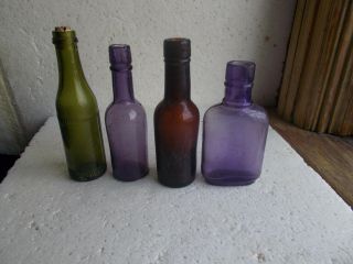 GROUP OF 4 DIFFERENT MINIATURE SAMPLE SIZE WHISKEY BOTTLES 2 AMETHYST HAND BLOWN 3
