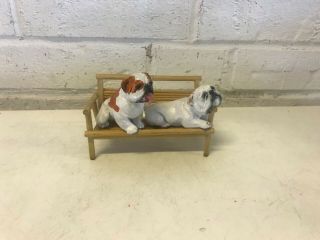 2 English Bulldog Resin Figurines Sitting On A Wooden Bench Brown & White