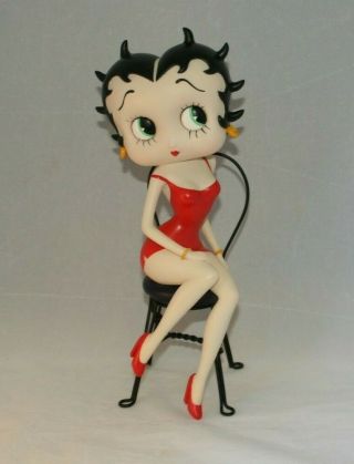 Large Betty Boop Figurine Sitting On Black Metal Chair In Red Dress