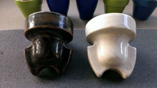 TWO ROMAN HELMET CABLE TOP PORCELAIN INSULATORS.  GLOSS WHITE AND MOLTEN COLORED 5