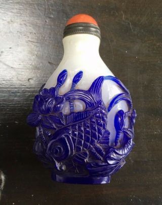 Chinese snuff bottle in white glass with deeply carved blue overlay of fish 2