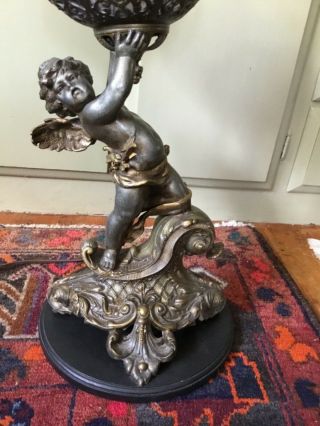 Art Nouveau Spelter Lamp With Winged Cherub Holding Up Urn With Faces Of Media
