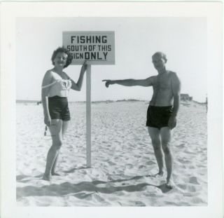 Couple On The Beach Next To " Fishing South Of This Sign Only " - B/w Snapshot