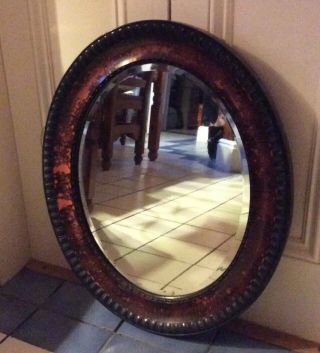Antique Oval Wall Mirror.  Bevelled.  Possibly Walnut) 25” X 22”.  Piece