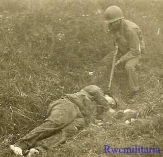 Somber Us Rifleman Checking The Body Of Kia German Soldier; France 1944