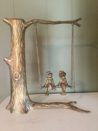 Vintage Brass Frogs Sitting On A Swinging Bench