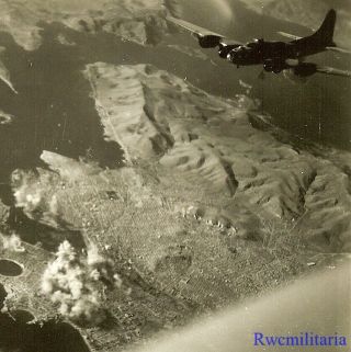 Org.  Photo: Aerial View B - 17 Bomber Passing Over Bombs Hitting Target Below