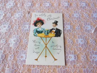 Victorian Christmas Card/seated Couple With Love Cup On Table Between Them