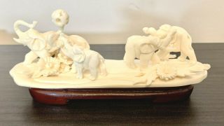 Vintage Ivory Colored Hand Carved Family Of Playing Elephants On A Wooden Stand