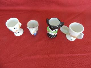 Four Vintage Egg Cups.  Mickey Mouse,  Butler,  Rabbit,  Peacock.