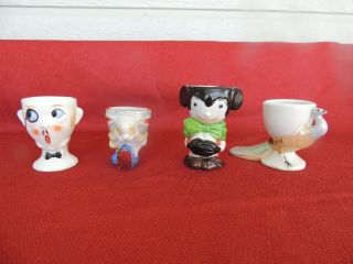 FOUR VINTAGE EGG CUPS.  MICKEY MOUSE,  BUTLER,  RABBIT,  PEACOCK. 2