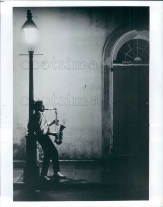 Press Photo French Quarter Night Scene Saxophone Player Against Lamp Post