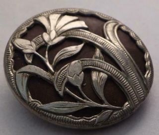 Vintage Metal Button With A Floral Design And Fabric Back Ground