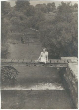 1930s Young Woman Sits On Wooden Bridge Over Waterfall Snapshot