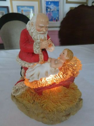Roman Inc.  Santa Kneeling Praying Over Baby Jesus Illuminated 5.  5 "