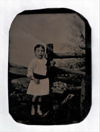 OLD VINTAGE ANTIQUE TINTYPE PHOTO YOUNG SHORT HAIR GIRL w/ SASH NEAR FENCE POST 2