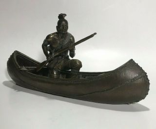 Native American Indian In Canoe With Gun And Axe Statuette