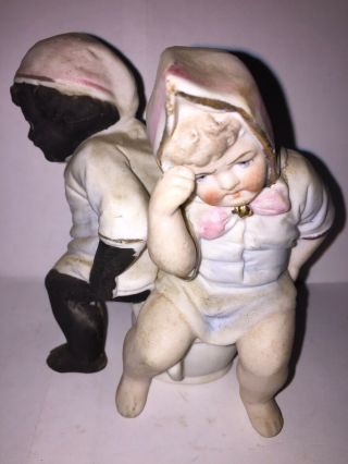 Bisque Figure Of A Black Boy And White Girl Sitting On The Same Chamber Pot. 2